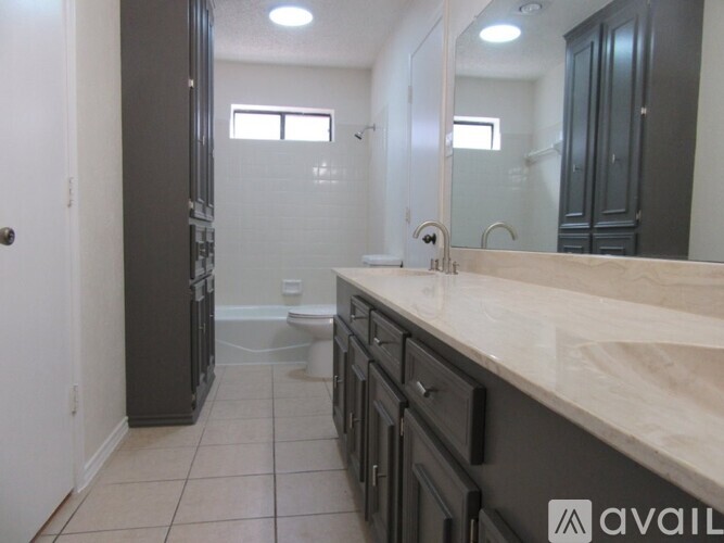 A bathroom with a marble countertop and a walk-in shower.