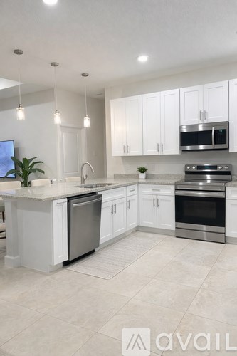 A modern kitchen with white cabinets and stainless steel appliances.