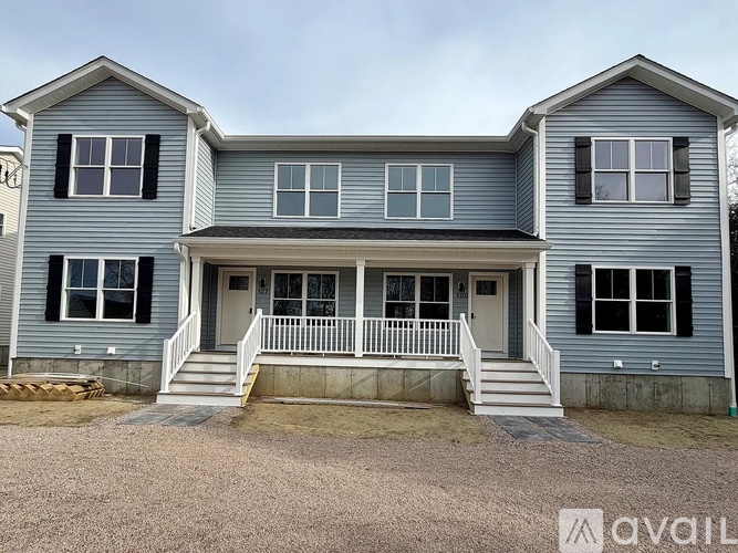 A two-story house with a front porch and multiple windows.