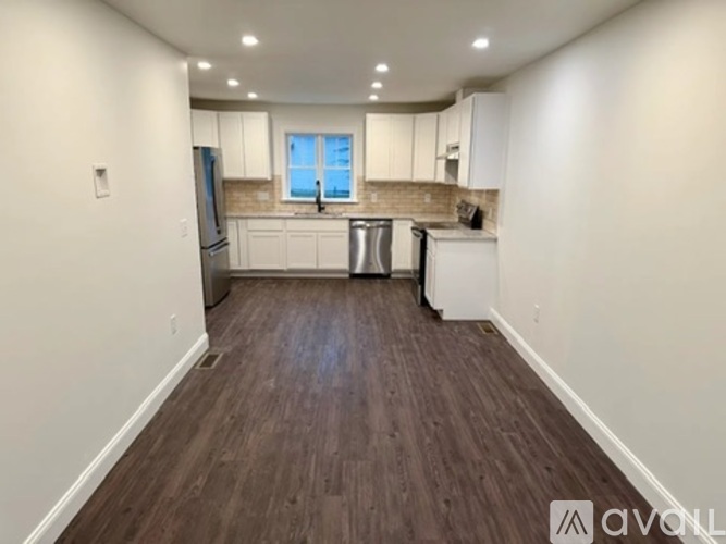 A kitchen with white cabinets and a window above the sink.