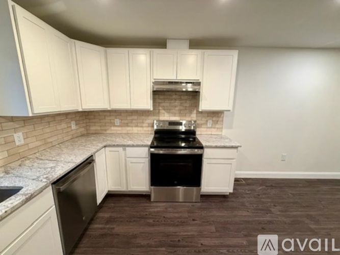 A kitchen with white cabinets and a black stove top oven.