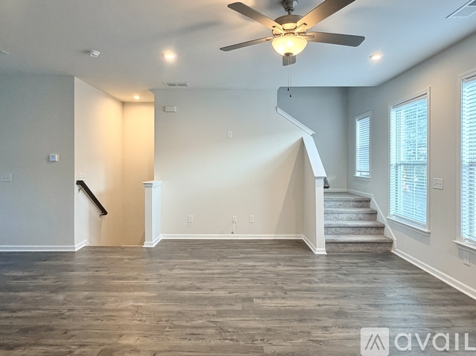 A spacious room with a staircase leading to the second floor.