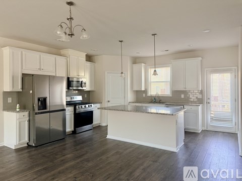 A modern kitchen with white cabinets and stainless steel appliances.