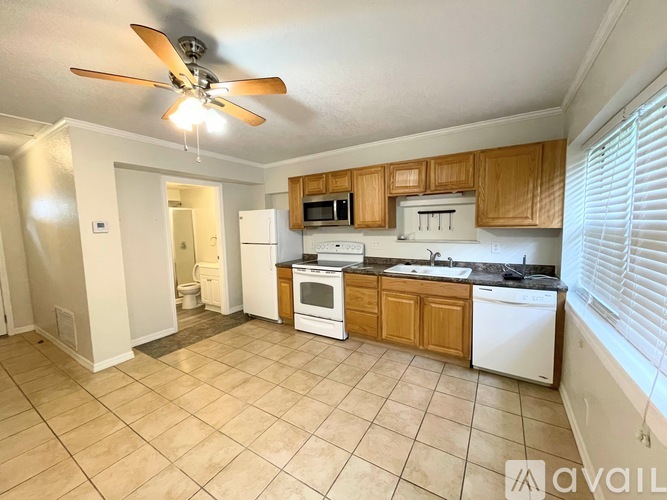 A kitchen with white appliances and wooden cabinets.