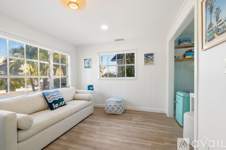 A living room with a white couch and a large window.