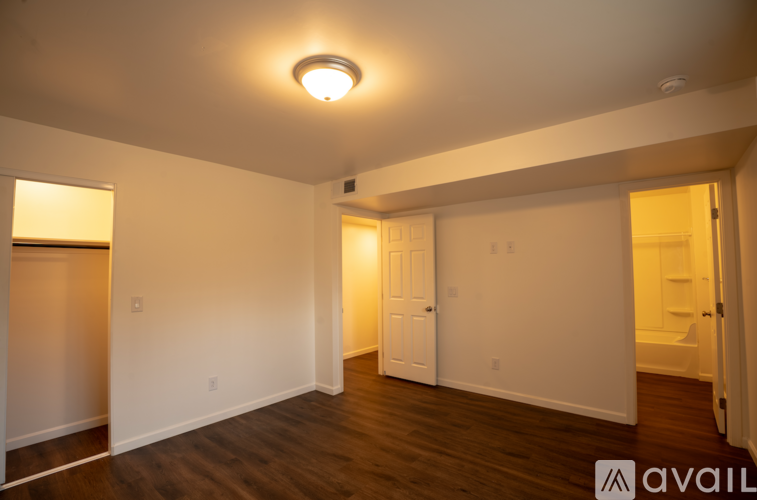A spacious room with a wooden floor and white walls.