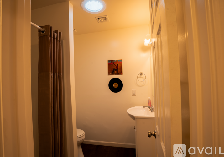A bathroom with a toilet, sink, and shower curtain.