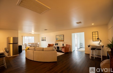 A living room with a white couch and a painting on the wall.