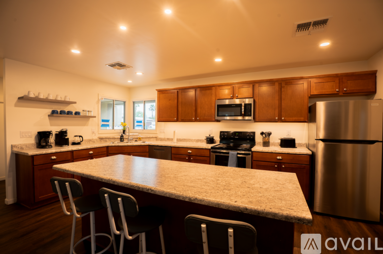 A kitchen with a table and chairs in the middle.
