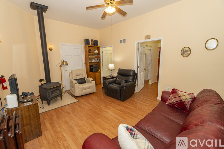 A living room with a red couch and a wood burning stove.