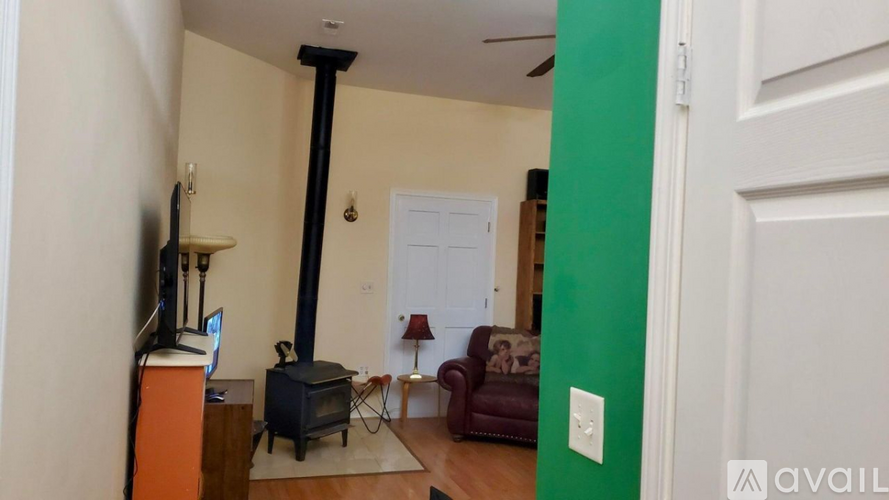 A living room with a wood burning stove and a television.
