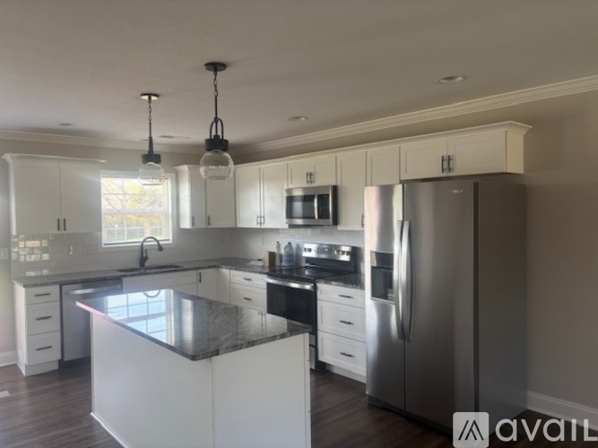A modern kitchen with a large island and stainless steel appliances.
