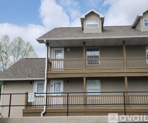 A two-story building with a balcony and a sign that says "CONTACT" is for sale.