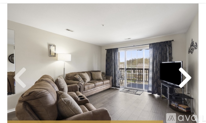 A living room with a large sectional sofa and a flat screen TV.