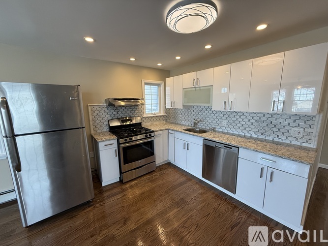 A kitchen with a refrigerator, stove, and cabinets.