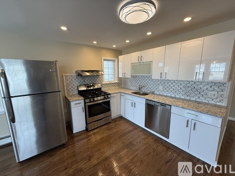 A kitchen with a refrigerator, stove, and cabinets.