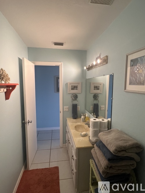 A bathroom with a sink, mirror, and towels.
