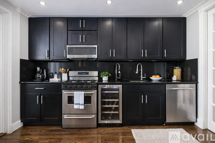 A kitchen with black cabinets and stainless steel appliances.