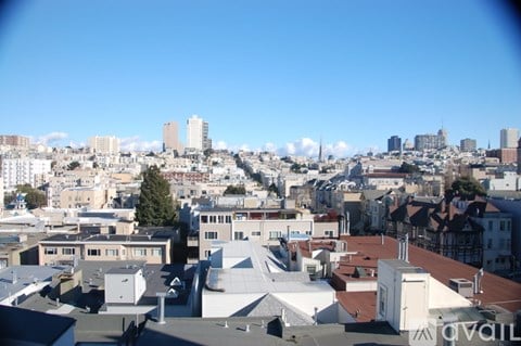 A cityscape with buildings of various sizes and shapes under a clear blue sky.