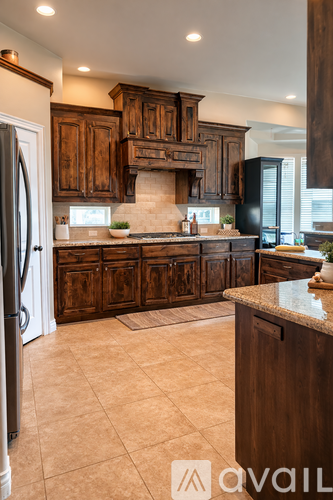 A kitchen with wooden cabinets and a marble countertop.
