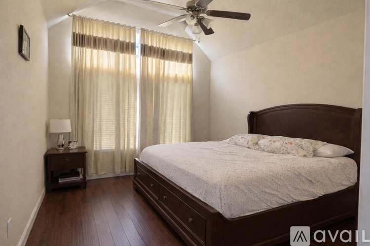A bedroom with a large bed and a ceiling fan.