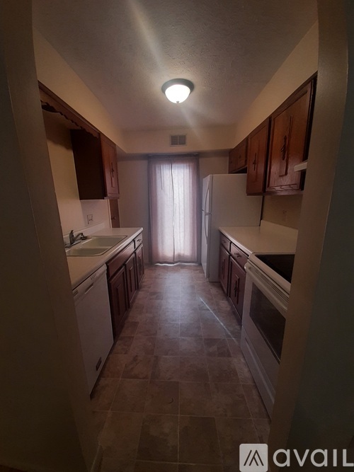 A kitchen with brown cabinets and a tile floor.