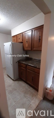 A kitchen with brown cabinets and a tile floor.