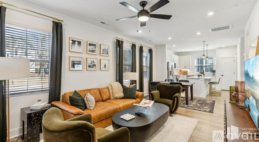 A living room with a brown couch and a ceiling fan.