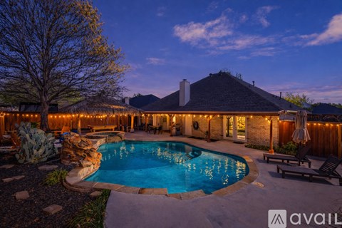A backyard with a pool and patio furniture.