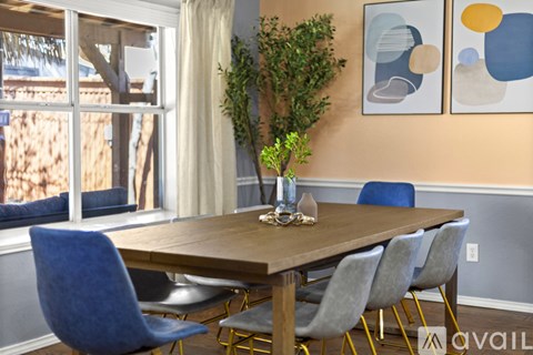 A dining room with a wooden table and blue chairs.