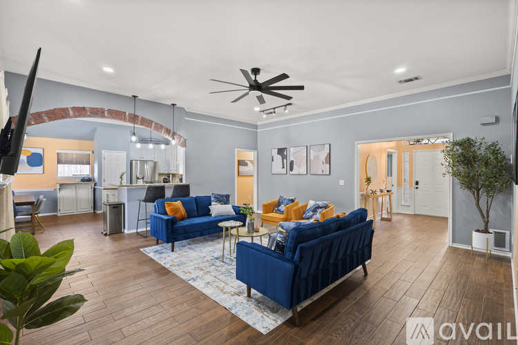 A living room with a blue couch and a ceiling fan.