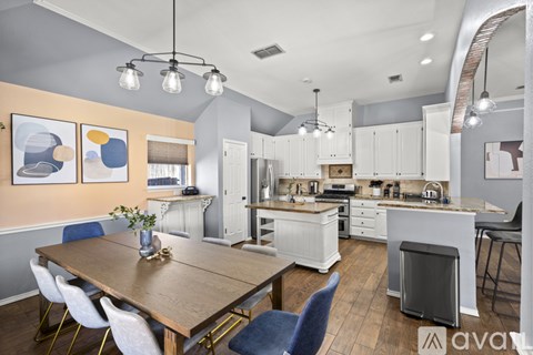 A kitchen with a dining table and chairs.