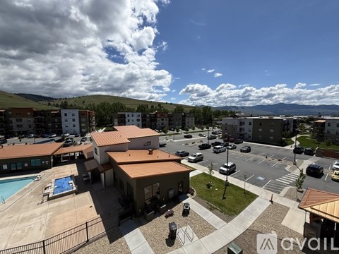 A view of a resort with a swimming pool and a parking lot.