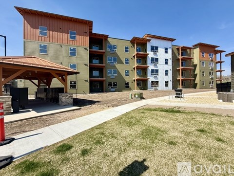 A row of multi-story apartment buildings with a clear blue sky above.