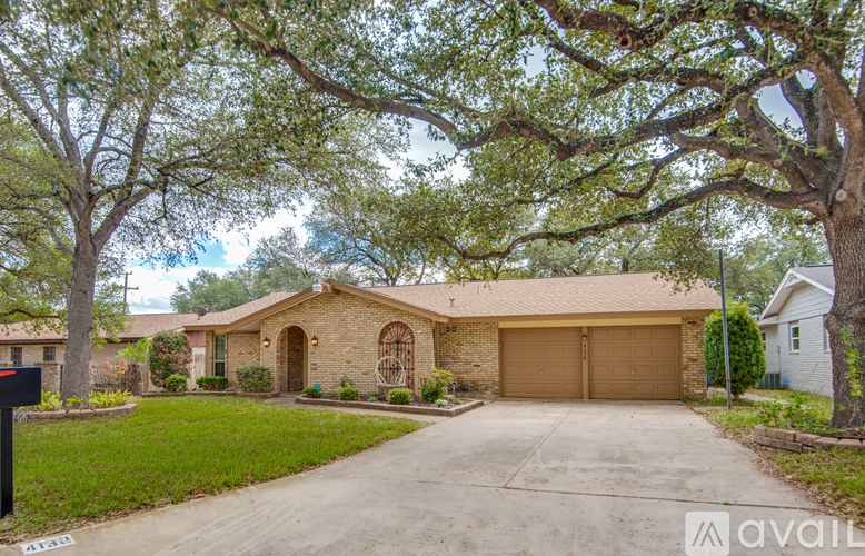 A house with a driveway and a tree in front.