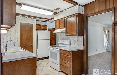 A kitchen with wooden cabinets and a white refrigerator.