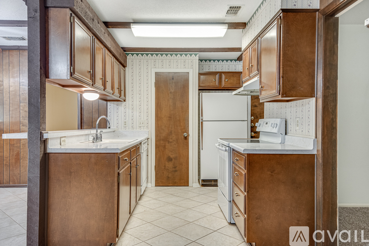 A kitchen with brown cabinets and a white fridge.