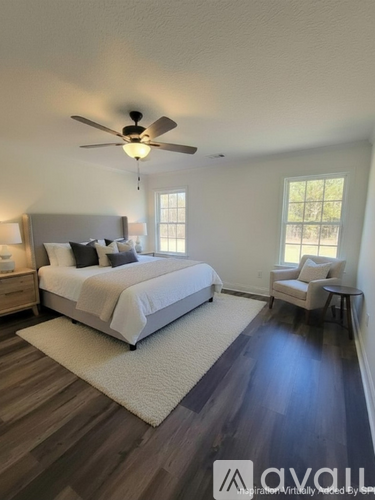 A bedroom with a bed, chair, and ceiling fan.