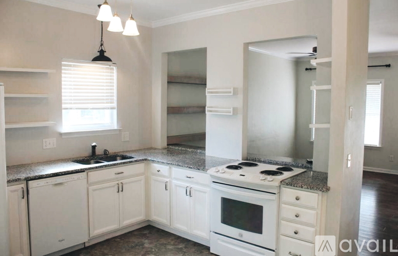 A kitchen with white cabinets and a granite countertop.