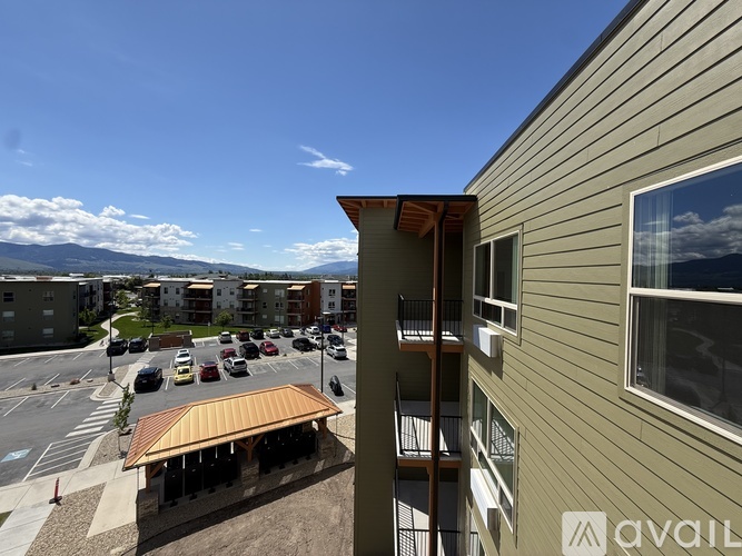 A building with a balcony overlooking a parking lot.