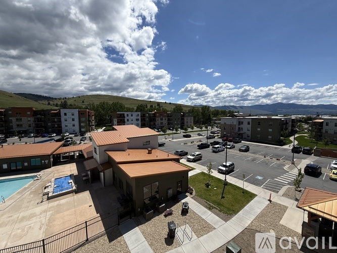 A view of a resort with a swimming pool and a parking lot.