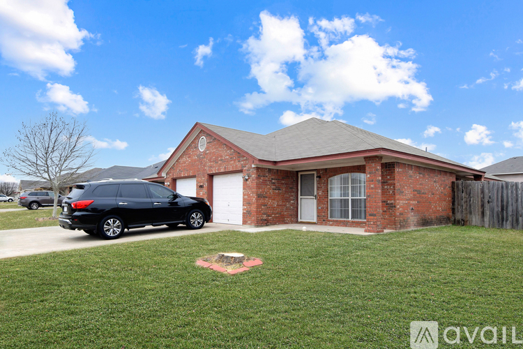 A black SUV is parked in front of a red brick house.
