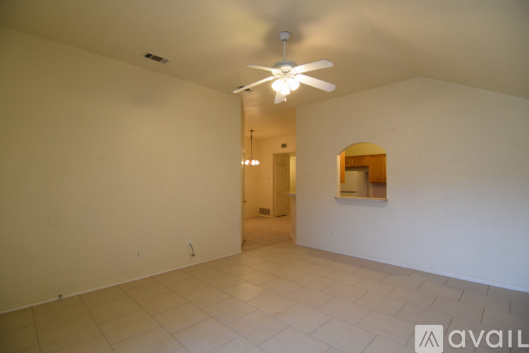 A spacious room with a ceiling fan and tiled floor.