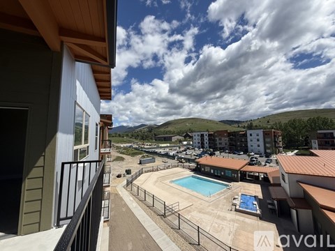 A view from a balcony overlooking a pool and apartment buildings.