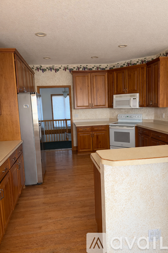 A kitchen with wooden cabinets and a white fridge.