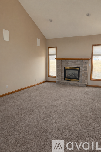 A living room with a fireplace and carpeted floor.