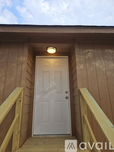 A white door is at the end of a wooden staircase.