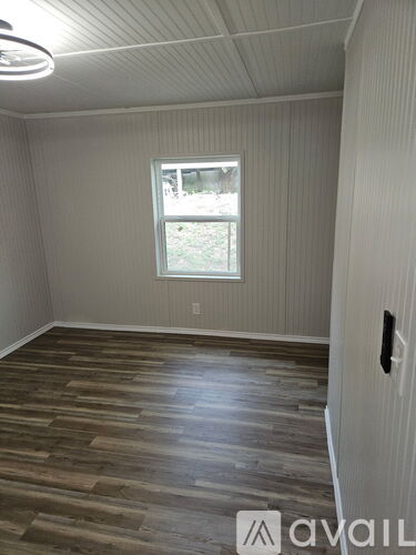 A room with wooden flooring and a window.