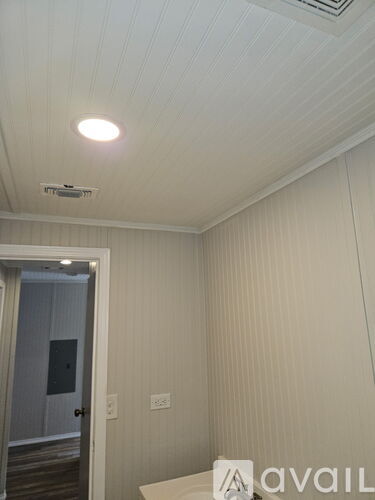 A white room with a door and a light on the ceiling.