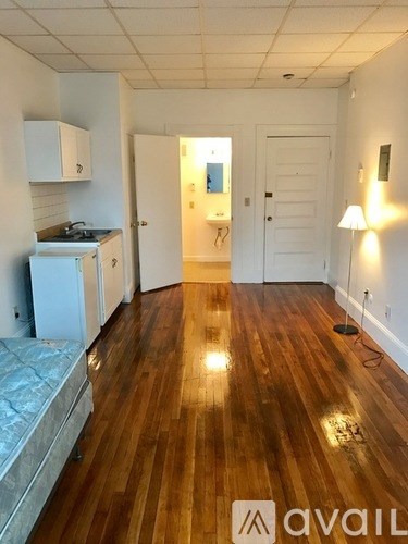 A kitchen with white cabinets and a wooden floor.